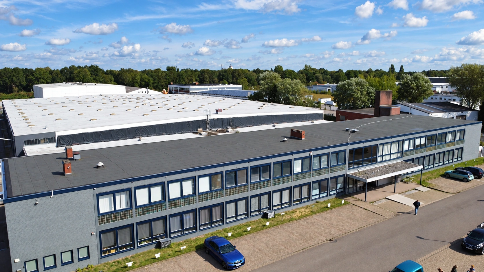 Aerial view of the building housing the Power Defence Group Bremen branch office, showing its blue-framed windows and entrance